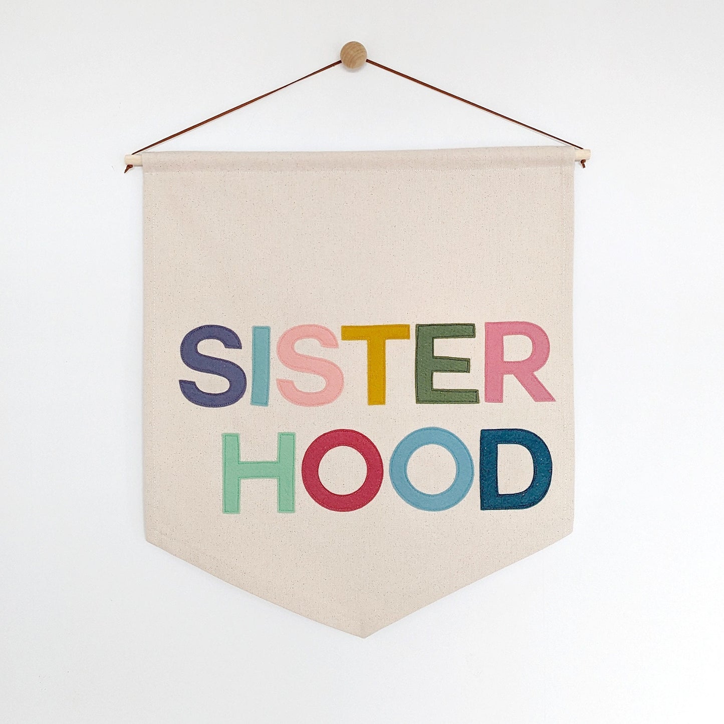 Sisterhood wall hanging in soft muted colours